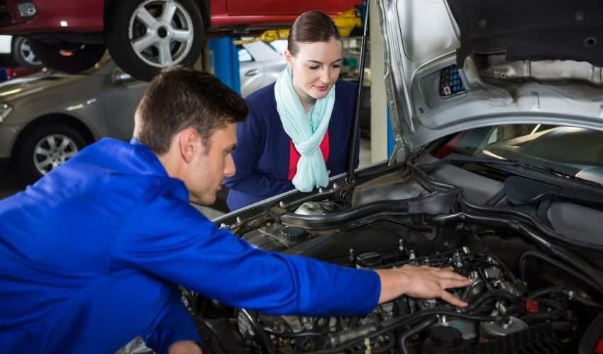mechanic-showing-customer-problem-with-car_1170-1566
